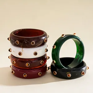 Detail of vintage marbled resin bangles with gold-tone rivet studs in various colors