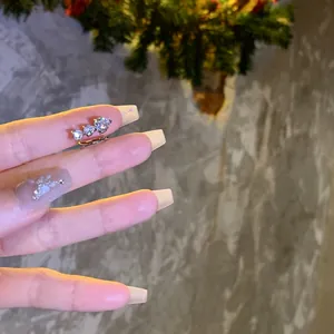 Primer plano de un ear cuff de circón brillante sostenido para ver los detalles.