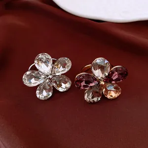 Vue détaillée de bagues fleurs en cristal facetté sur un fond de tissu luxueux rouge