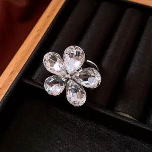 Gros plan détaillé d'une bague fleur en argent avec de brillants cristaux en goutte
