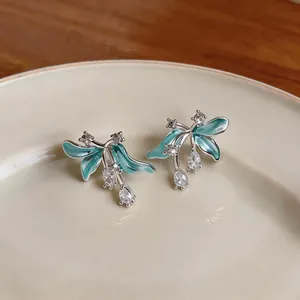 Vue détaillée des boucles d'oreilles fleurs en émail avec des zircons clairs et brillants