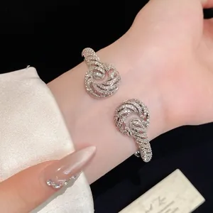 Elegant 18K gold-plated twisted open bangle with shimmering cubic zirconia stones