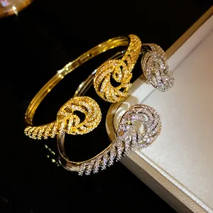Detailed macro view of elegant 18K gold plated twist bangles with sparkling cubic zirconia stones
