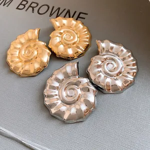 Dettaglio di orecchini a perno a forma di conchiglia nautilus oro e argento lucido
