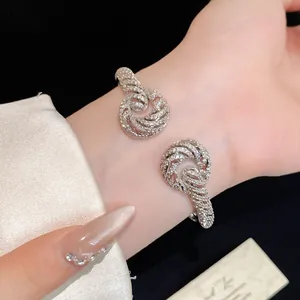 Close-up of elegant 18K gold plated zircon encrusted twisted open bangle bracelet
