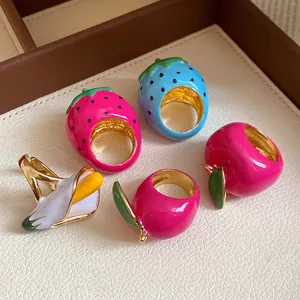 Vibrant enamel fruit-shaped rings featuring strawberry and banana designs for summer