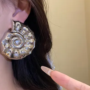 Dettaglio di un grande orecchino a lobo a forma di conchiglia ammonite argento