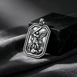 Detailed view of vintage stainless steel St. Michael military tag pendant on marble