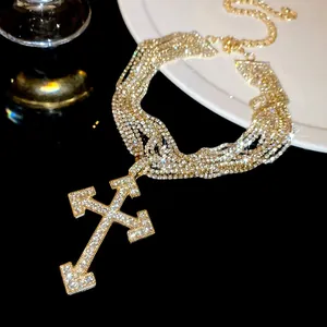 Detailed view of luxury multilayer rhinestone cross pendant necklace in gold