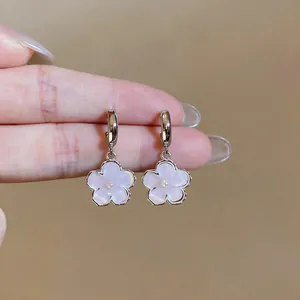 Close-up detail showing the delicate texture of sweet resin flower pendant earrings with a pearl