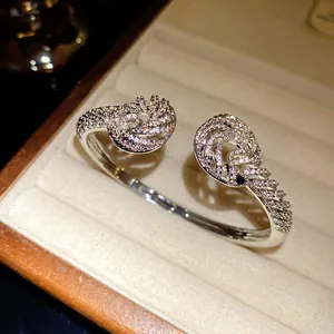 Close-up of twisted 18K gold plated open bangle with sparkling zircons in a box