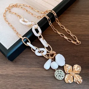 Detailed view of the gold flower pendant and resin chain links on this vintage style necklace