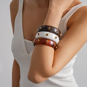 Set of vintage resin marbled bangles with gold studs displayed on a female model arm