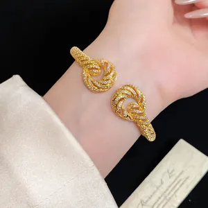 Close-up of elegant 18K gold plated twisted bangle with shimmering cubic zirconia