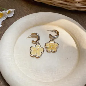 Detailed view of sweet yellow resin flower pendant earrings with a white pearl center