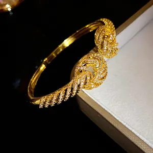 Close-up of 18K gold plated bangle with intricate twisted patterns and zircons