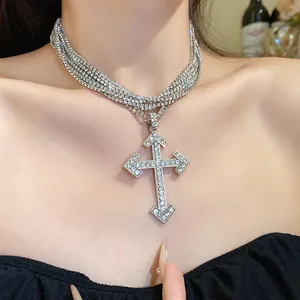 Close-up of a multi-layered necklace with a large sparkling rhinestone cross pendant