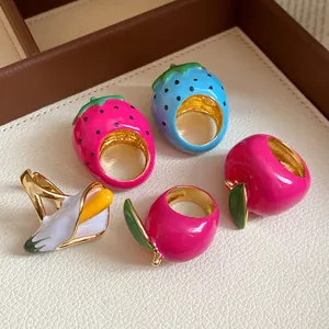 Detailed view of colorful enameled fruit rings including strawberry and banana designs
