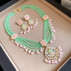 Exquisite detail of vintage green beaded necklace and earrings with pink accents