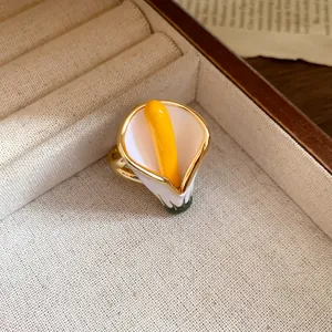 Elegant detail of a calla lily enamel ring with yellow stamen inside a jewelry box