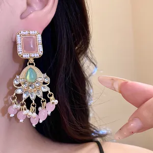 Detailed view of vintage chandelier earring with pink resin stones and pearls