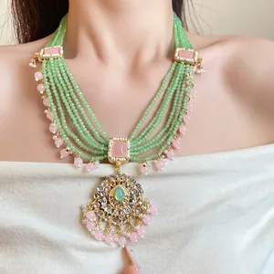 Detailed view of a multi-layer vintage necklace with green beads and pink resin stones.