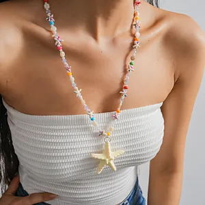Vue détaillée d'un collier de perles en résine avec étoile de mer porté par un mannequin.
