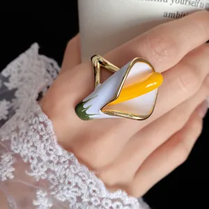 Detailed macro view of a calla lily enamel ring with vibrant white and yellow accents
