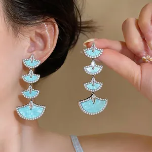 Elegant silver fan-shaped dangle earrings with blue marble inlay and sparkling zircons.