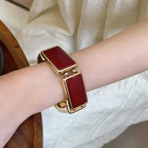 Detailopname van de vintage armband met rechthoekige rode emaille inzetstukken.