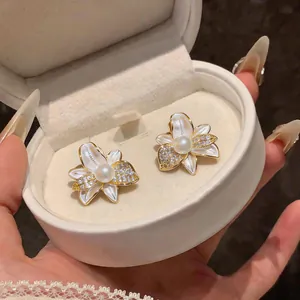 Primer plano de elegantes pendientes de flores con perlas y cristales en caja de regalo