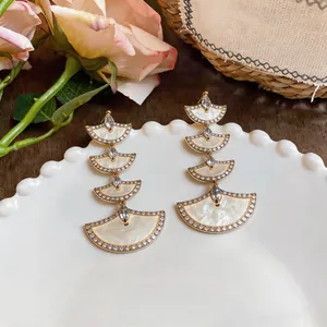 Close-up view of elegant 18k gold plated fan-shaped earrings with shimmering zircons