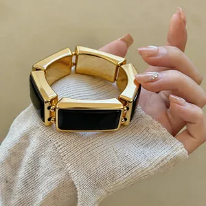 Gedetailleerd overzicht van een vintage gouden en zwarte rechthoekige schakelarmband