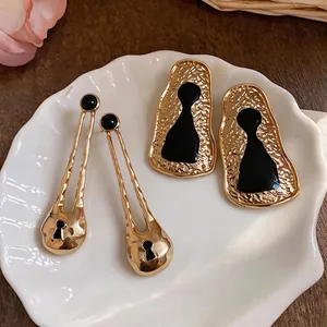 Chic gold hammered geometric drop earrings with black keyhole silhouette motif design