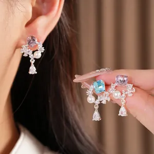 Vue détaillée de boucles d'oreilles en argent avec zircons violets, bleus et perles blanches