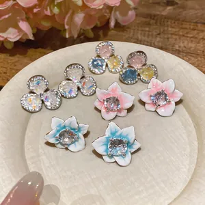 Detailed close-up view showing assorted zircon flower stud earrings with elegant enamel finish.