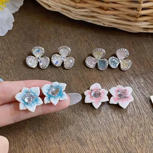 Close-up detail of silver needle zircon flower stud earrings in multiple colors
