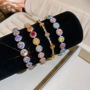 Detailopname van vier schitterende 18k vergulde zirkonia-armbanden op een fluwelen standaard