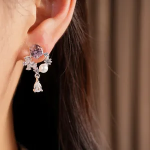 Vue détaillée de boucles d'oreilles en argent avec gouttes de zircone et perles