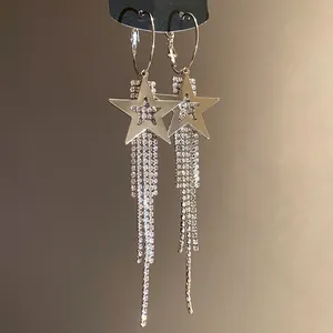 Close-up detail of silver star earrings with long rhinestone tassels and elegant sparkle