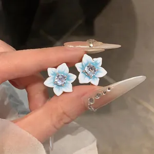 Detailed view of elegant blue and white gradient flower stud earrings with a clear zircon