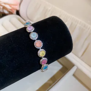 Close-up van 18k vergulde armband met veelkleurige ronde zirkonia op een zwarte fluwelen standaard