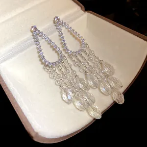 Detalle de pendientes colgantes con circón, perlas y cristales en una caja de regalo