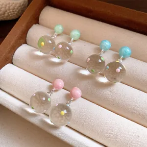 Clear polka dot glass ball drop earrings with colorful pastel beads in a jewelry box.