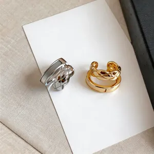 Detailed macro view of gold and silver quilted double-layer ear bone clips on a white card.