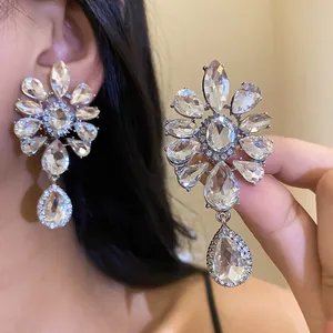 Close-up detail showing exquisite rhinestone flower earrings with elegant teardrop crystals