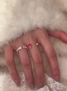 Dettaglio ravvicinato dell'anello regolabile in argento con fragola e stella sulla mano
