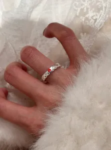 Dettaglio ravvicinato di un anello in pizzo argento vintage con ciondolo a fragola
