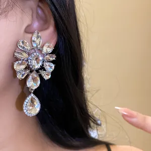 Close-up of luxury flower-shaped rhinestone ear clip with dangling water drop