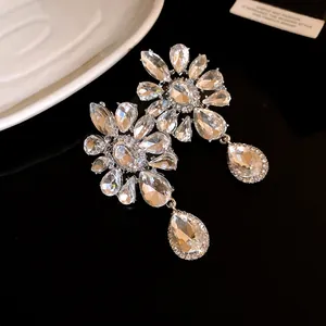 Close-up macro view of faceted clear crystals on floral rhinestone drop earrings.